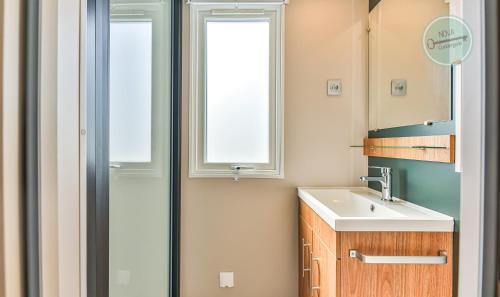 une salle de bain avec un lavabo et une fenêtre dans l'établissement Le Bois Dormant 761 by NOVA, à Saint-Jean-de-Monts