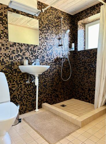 a bathroom with a shower and a sink and a toilet at Lehtla Puhkekompleks in Austla