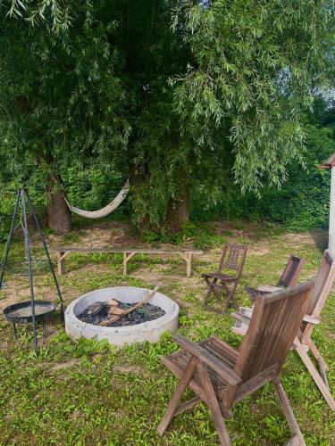 a yard with two chairs and a fire pit at V dedine a predsa mimo nej v maringotke na samote in Dechtice