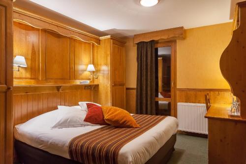 a bedroom with a bed with wooden cabinets at Hôtel Les Balcons Village in Belle Plagne
