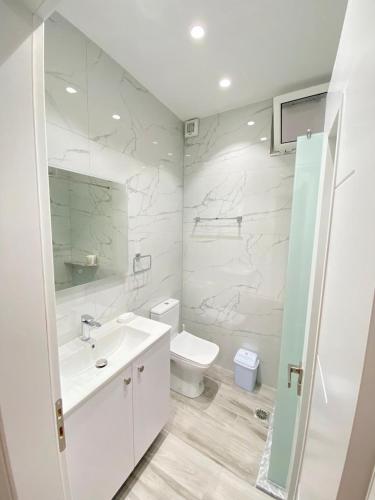 Valbona Apartment في سارنده: حمام أبيض مع حوض ومرحاض