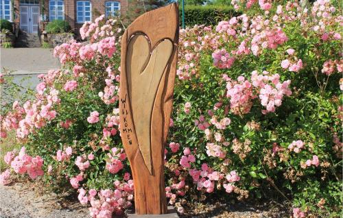 a wooden bench in a bed of pink flowers at 3 Bedroom Cozy Home In Thandorf in Thandorf