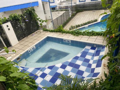 a large swimming pool with blue and white tiles at Casa de descaso en Carmen de apicala in Carmen de Apicalá