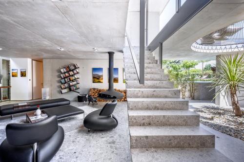 a staircase in a living room with black furniture at Le Pavillon M, Piscine et Spa au pied du château, Petit-Déjeuner inclus, Parking privé in Grignan