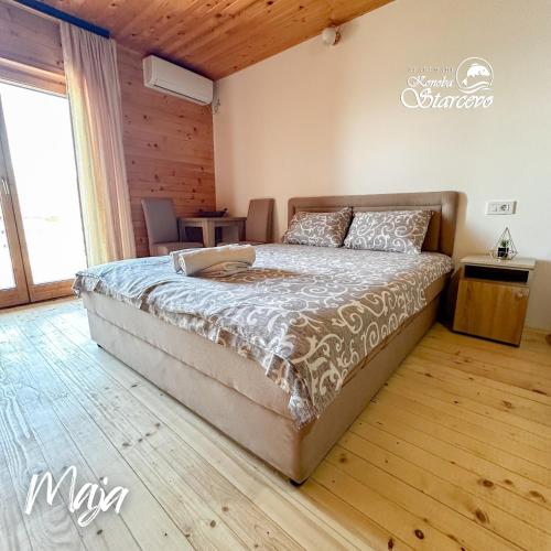 a bedroom with a large bed with a wooden floor at Apartmani Konoba Starčevo in Virpazar