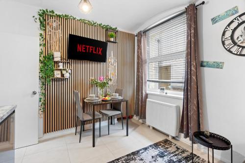 Stylish 1-Bedroom Apartment near Beach - Brighton في برايتون أند هوف: غرفة طعام بها طاولة وكراسي ونافذة