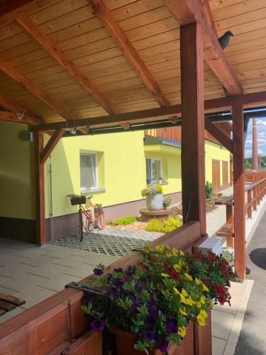 a wooden pergola with flowers on a patio at Penzion Pod pecí in Lenora