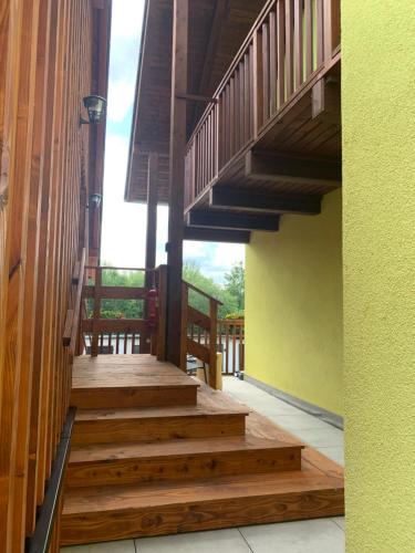 a porch with wooden stairs in a house at Penzion Pod pecí in Lenora