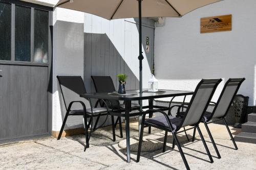 a table and chairs with an umbrella on a patio at Apartman Tina in Rakovica
