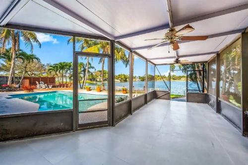 sala de estar de planta abierta con piscina y ventilador de techo en Modern, 4B&3B with Pool and Lake, en Pembroke Pines