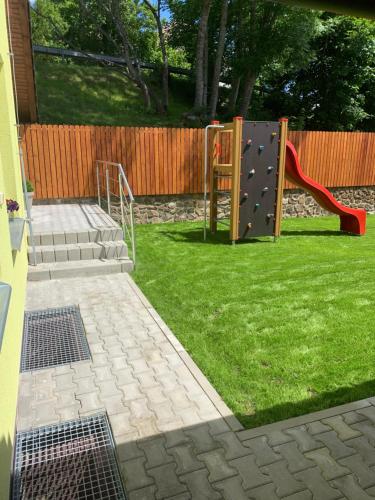 a playground with a slide in a yard at Penzion Pod pecí in Lenora