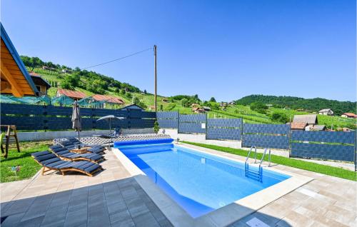 a swimming pool with two lounge chairs and a fence at Cozy Home In Vrhi Pregradski With Sauna in Pregrada