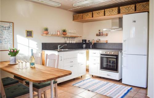 cocina con mesa de madera y nevera blanca en 2 Bedroom Lovely Apartment In Borgholm, en Borgholm