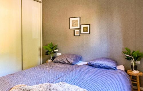 a bedroom with a blue bed with two pillows at Stunning Home In Heinkenszand With Wifi in Heinkensand