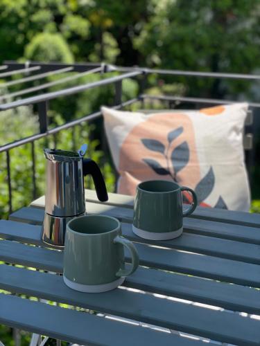 two coffee mugs on a blue picnic table at Blu Iris - Deluxe apartment with jacuzzi in Lesa