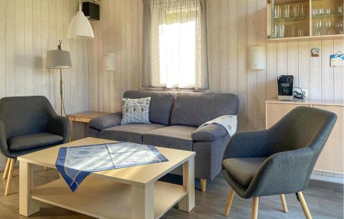 Una sala de estar con un sofá y dos sillas y una mesa. en Schatzkiste 11 - Dorf 4, en Travemünde