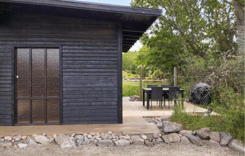 Un cobertizo de madera con una mesa y un comedor. en Amazing Home In Hasslö, en Hasslö