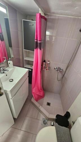 a bathroom with a shower with a pink shower curtain at Kontili house in Skiros