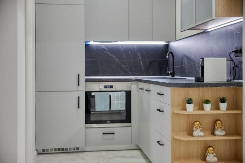 a kitchen with white cabinets and a stove top oven at CityLife Residence in Bratislava