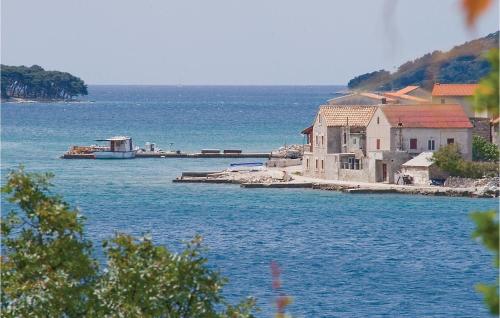 a large body of water with houses and a boat at Apartment Sibenik With Sea View Xiii in Krapanj