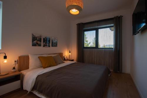 a bedroom with a large bed and a window at Hyggemate - Nordic Villa with Sauna & Jacuzzi Retreat in Sarnitsa