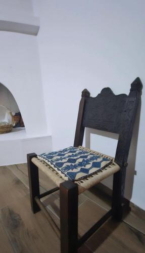 a wooden chair with a checkered seat in a room at Kontili house in Skiros