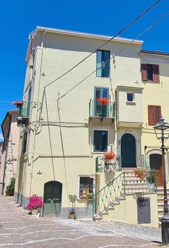 a yellow building with flower boxes on the balconies at Il Campanile in Santa Maria del Molise