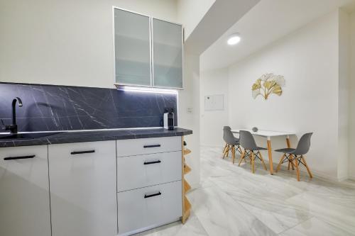 a kitchen with white cabinets and a table with chairs at CityLife Residence in Bratislava