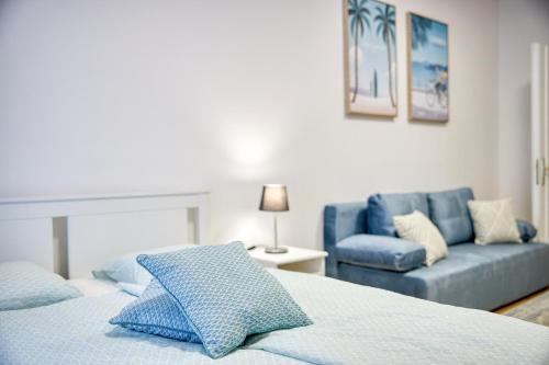 a bedroom with a bed and a blue couch at CityLife Residence in Bratislava