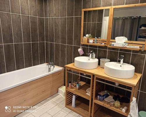 a bathroom with two sinks and a tub and a mirror at La maison de Ghislaine in Argelès-sur-Mer