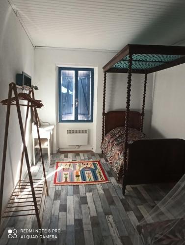 une chambre avec un lit à baldaquin et une fenêtre dans l'établissement La maison de Ghislaine, à Argelès-sur-Mer