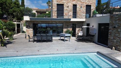 une cour arrière avec une piscine et une maison dans l'établissement Villa Ronsard - vue mer, à Fréjus