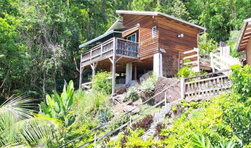 a wooden house with a porch and a balcony at Le Bougainvillier Blanc in Pointe-Noire
