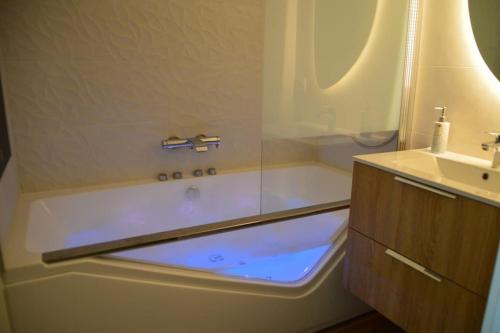 ドーヴィルにあるMini-duplex cosy avec magnifique vue merのバスタブと洗面台のあるバスルーム