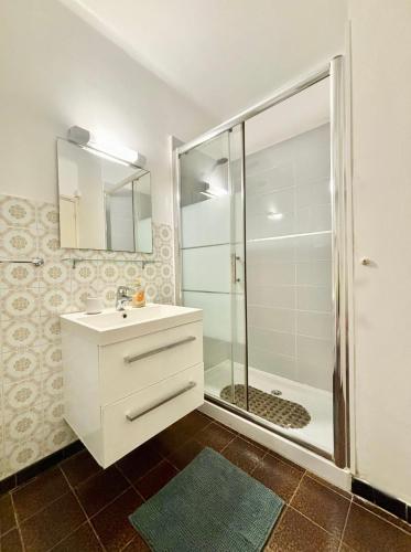 une salle de bain avec un lavabo blanc et une douche dans l'établissement A 20min d AJACCIO, Grand studio 3 personnes - pieds dans l'eau - accès direct plage - vue mer exceptionnelle, à Casaglione