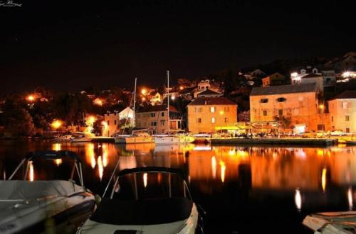 a harbor at night with boats in the water at Apartment Karla in Splitska