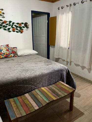 a bedroom with a bed with a bench on it at Pouso Bem Estar in Tiradentes