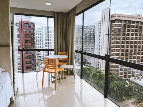 Una habitación con balcón con mesa y sillas. en 1138 Flat Triplo Garvey - Esplanada e Congresso, en Brasilia