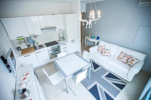 un salon avec un canapé blanc et une table dans l'établissement Résidence Les Palmiers by Connexion, à Cannes