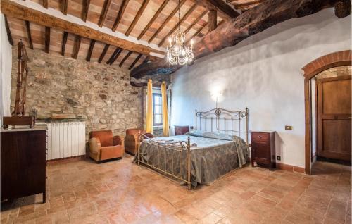 a bedroom with a bed and a stone wall at Materno 3 in Monteguidi