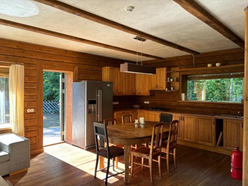 a kitchen with a table with chairs and a refrigerator at Lehtla Puhkekompleks in Austla