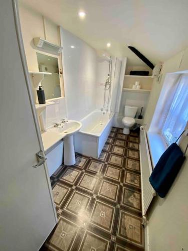 a bathroom with a sink and a tub and a toilet at Carefree Cottage in Marstow