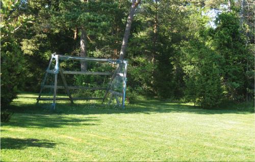 a blue swing set in a field with trees at Holiday Home Lärbro 46 in Valleviken