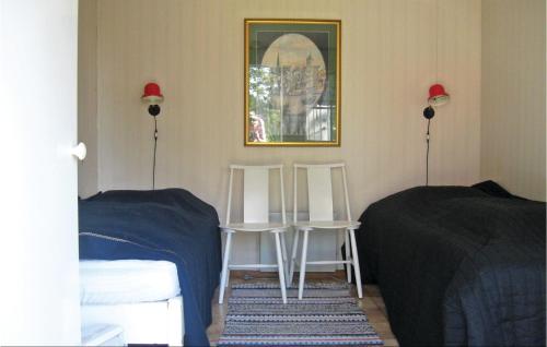 a bedroom with two chairs and a table and a mirror at Holiday Home Lärbro 46 in Valleviken