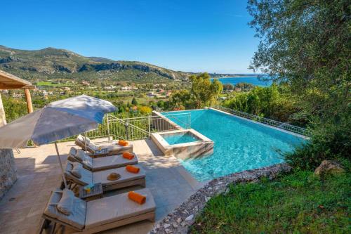 a swimming pool with a table and an umbrella at Villa Katelios Bay View by Villa Plus in Katelios