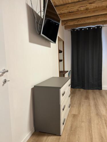 a room with a dresser and a tv on the wall at Larocca Tourist Home 3 Valbrenta in Carpane