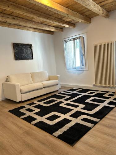 a living room with a couch and a rug at Larocca Tourist Home 3 Valbrenta in Carpane