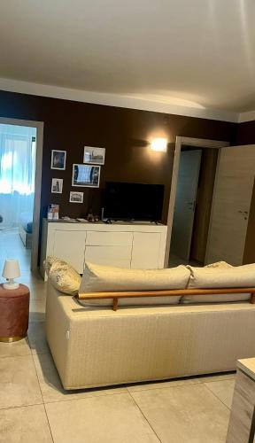 un soggiorno con divano e TV a schermo piatto di Sweet Home a Savigliano