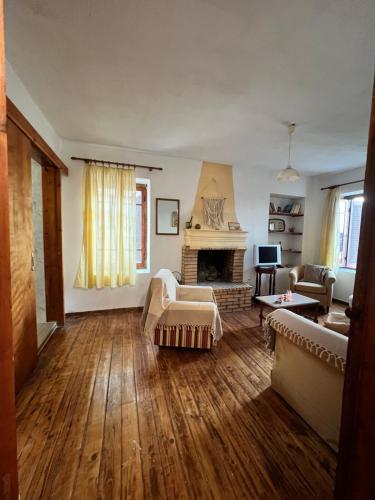 a living room with a couch and a fireplace at Village House in Petaloú