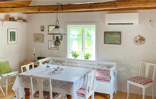 a dining room with a white table and chairs at Holiday Home Linghult, Isaka Stuga Eldsberga in Plingshult